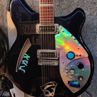 the modified Ric with a new pickguard and lots of controls, including a blue-guarded toggle